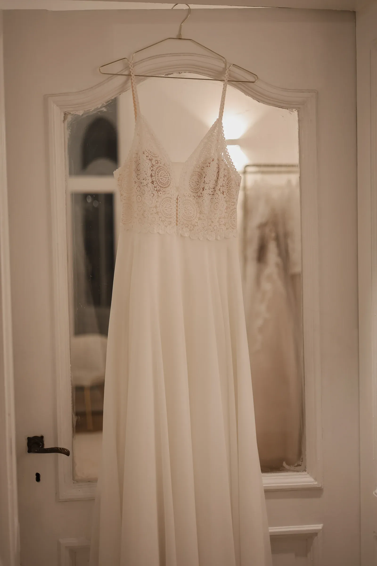 Brautkleid mit Spitzenoberteil am Bügel in der Boutique
