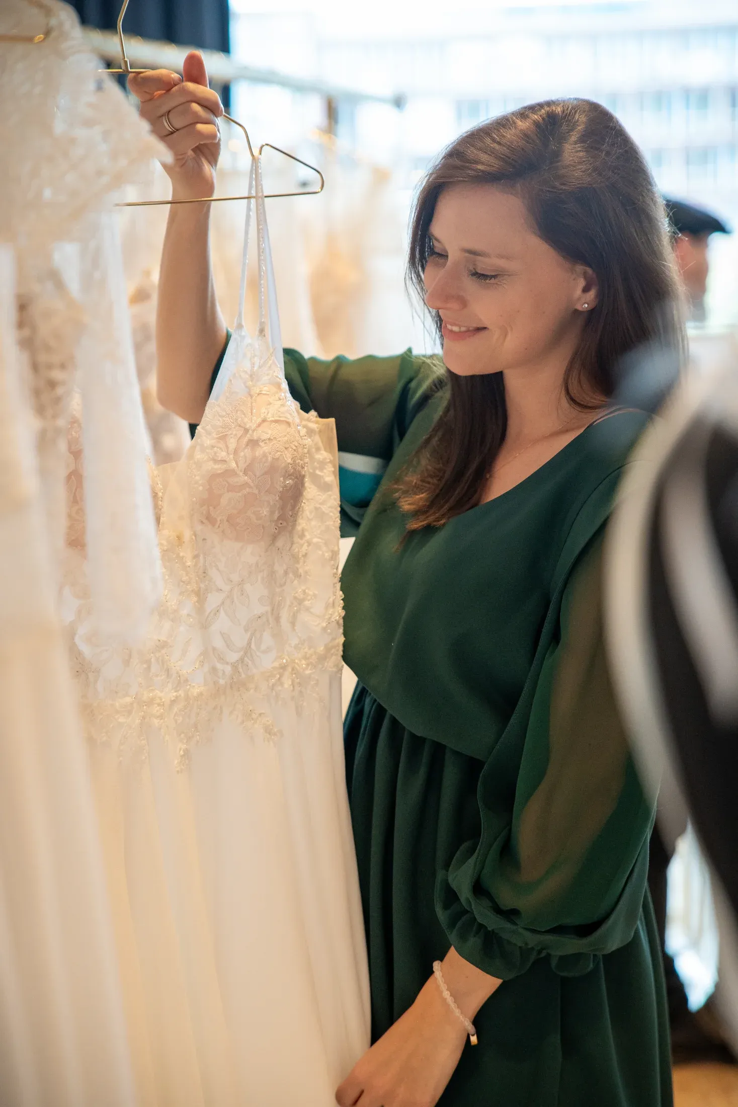Jacqueline betrachtet ein Brautkleid in ihrer Boutique