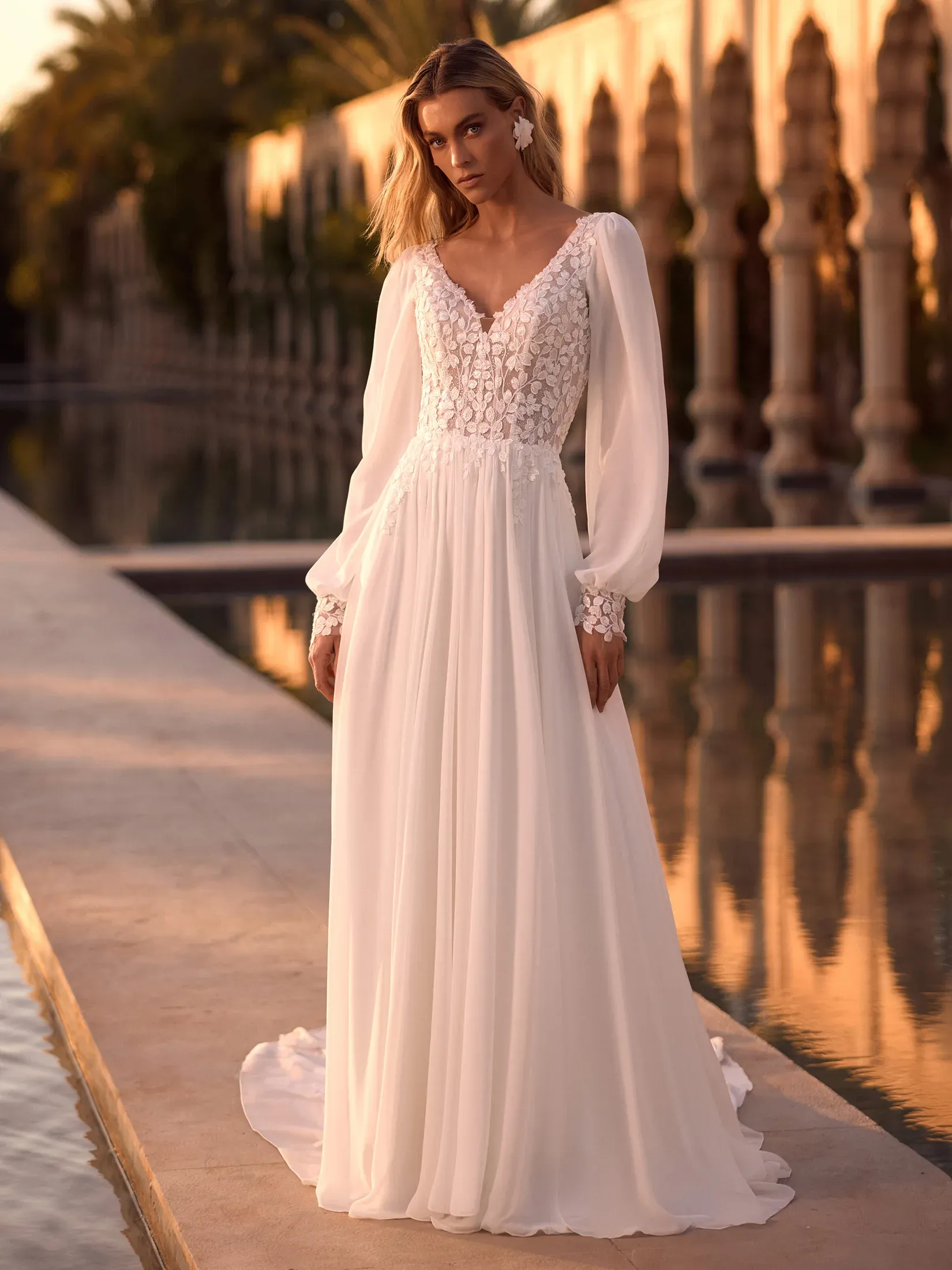Brautkleid mit Blütenspitze am Oberteil, V-Ausschnitt, langen transparenten Ärmeln und fließendem Rock