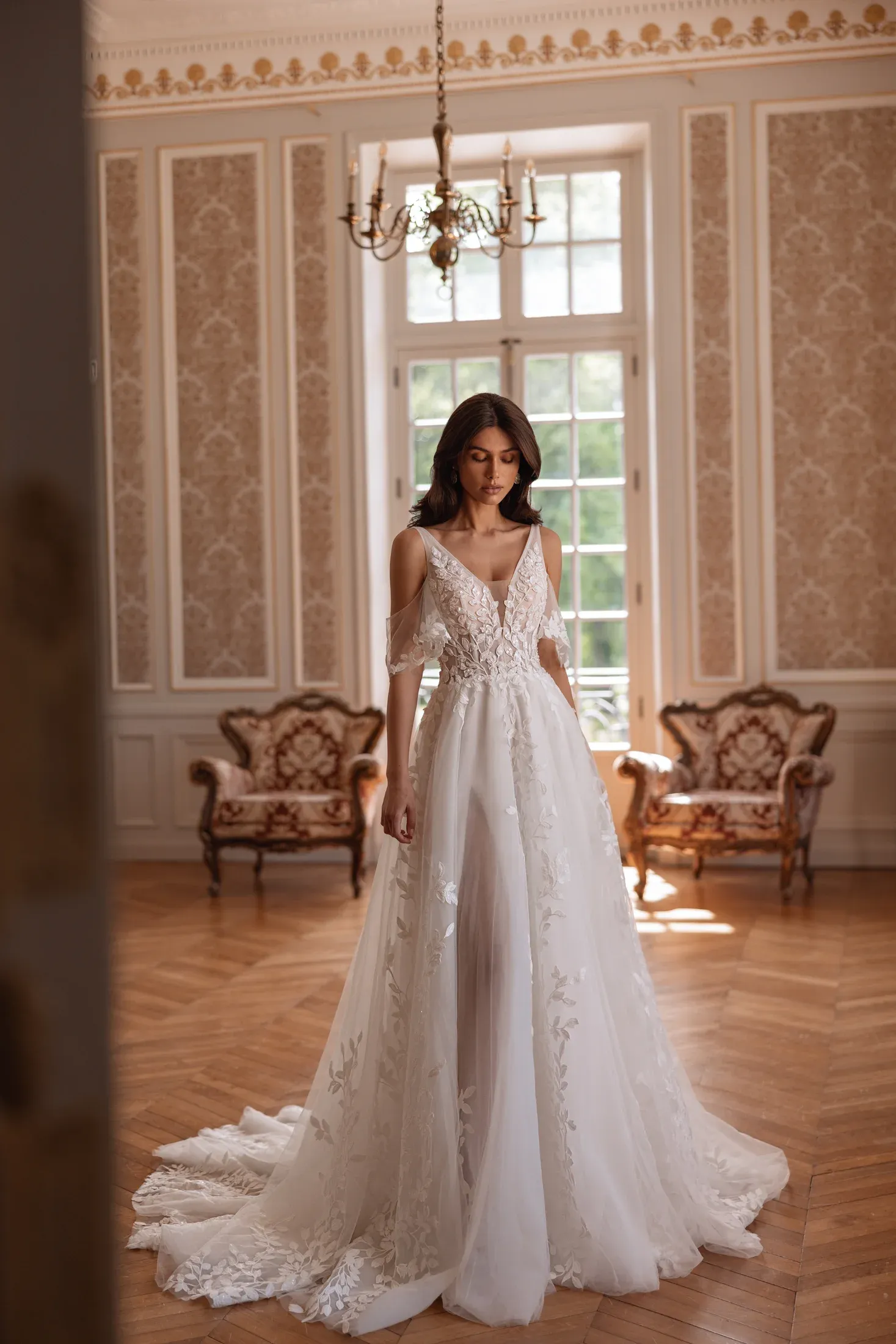 Brautkleid in A-Linie mit V-Ausschnitt, zarten Tüllärmeln und floraler Spitze auf dem weiten Tüllrock