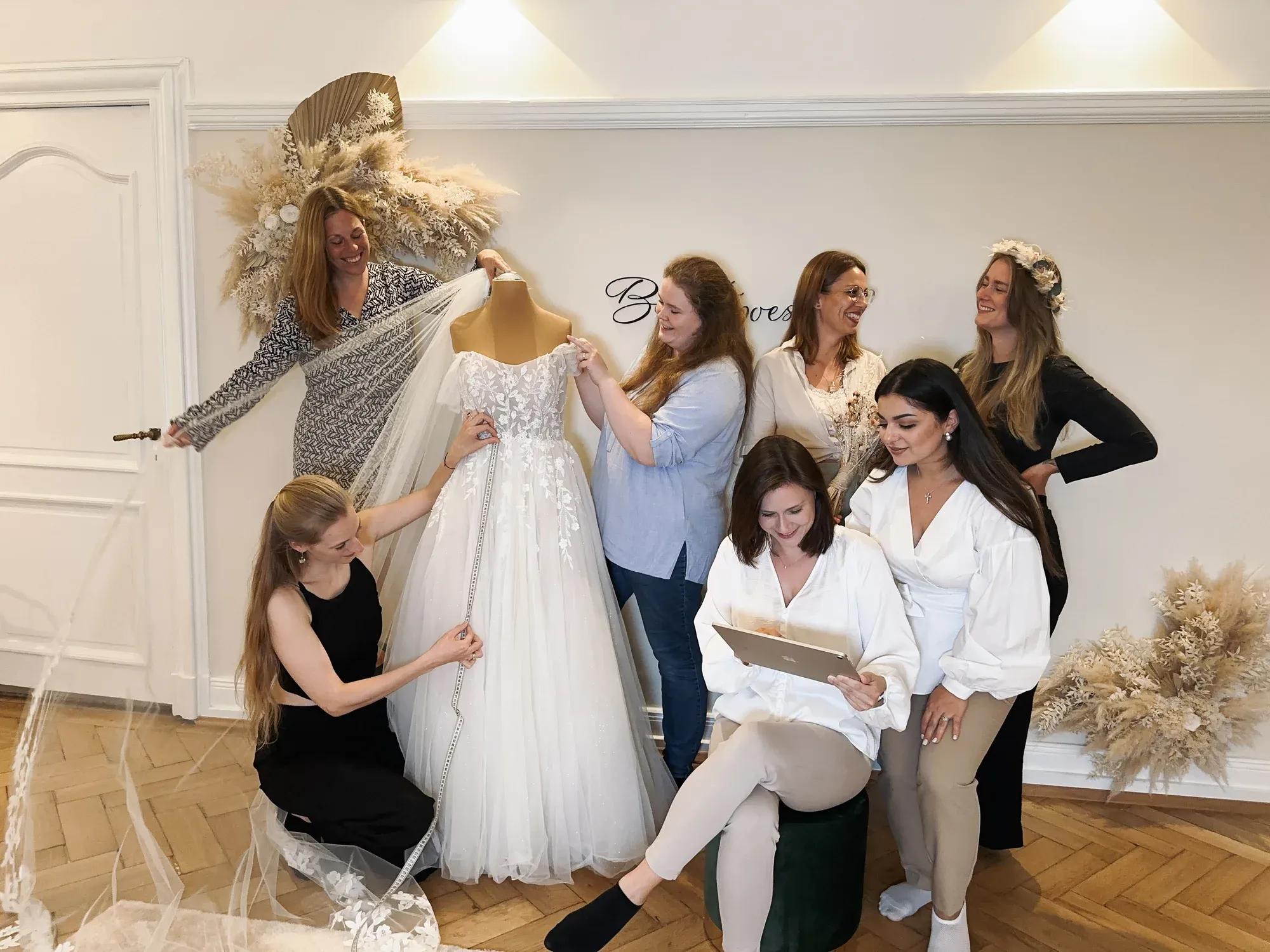 Das Brautpoesie-Team gemeinsam mit einem Brautkleid